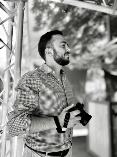 Tarifs 3 Portrait en noir et blanc de Thomas Pampillonia, photographe à Marseille, tenant son appareil photo.