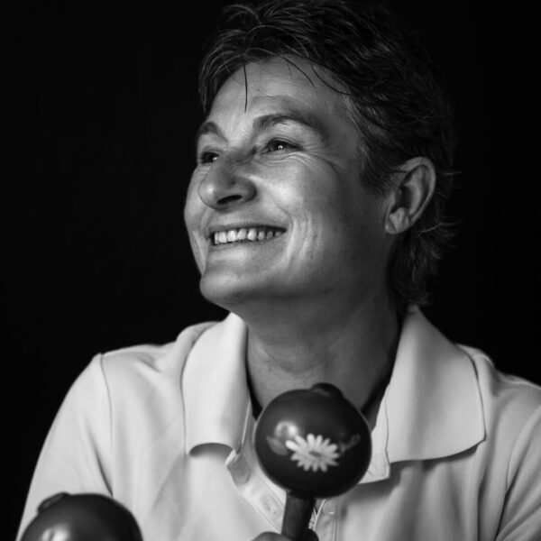 Photographe Portrait Marseille 5 Portrait en noir et blanc d’une femme souriante jouant avec des maracas, capturant une ambiance dynamique et joyeuse.