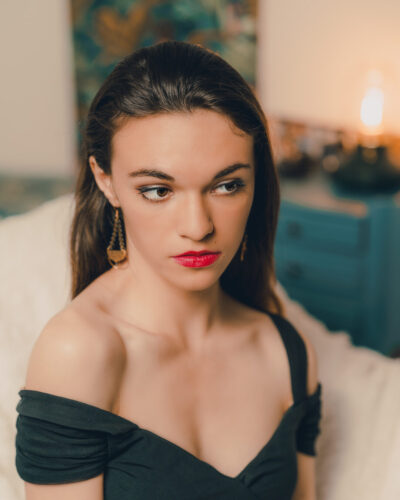 Tarifs 10 Portrait élégant d’une femme au regard intense, capturé dans une ambiance intimiste et chaleureuse à Marseille.